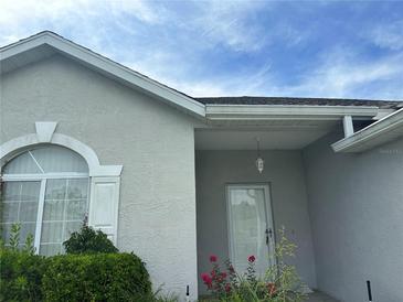 Inviting house exterior featuring a light gray facade, lush landscaping, and a covered entryway at 2352 Nw 53Rd Avenue Rd, Ocala, FL 34482