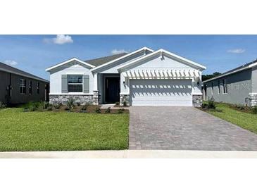 Inviting single-story home boasting a well-manicured lawn, stone accents, and an attractive two-car garage at 4062 Nw 48Th Terrace Rd, Ocala, FL 34482