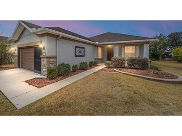 One-story home with brown garage door, landscaping, and walkway at 7454 Sw 101St Ave, Ocala, FL 34481