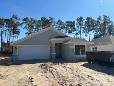 Newly constructed home with a gray exterior, two-car garage, and landscaping at 7658 Sw 180Th Cir, Dunnellon, FL 34432