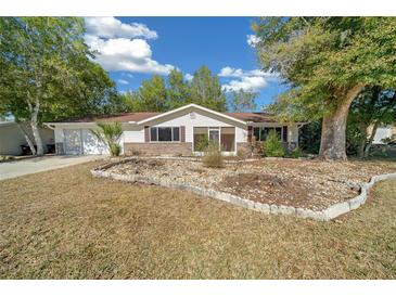 Charming single-story home features a well-maintained front yard with mature trees and a two-car garage at 8639 Sw 116Th Lane Rd, Ocala, FL 34481