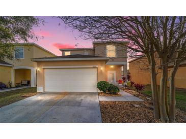 Charming two-story home with a two car garage, beautiful landscaping, and a walkway to the front door at 12312 Ne 48Th Loop, Oxford, FL 34484