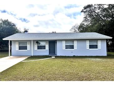 Charming single story home with blue exterior, white trim and a well-maintained front yard at 1904 Ne 50Th St, Ocala, FL 34479