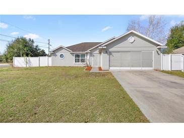 Charming single-story home featuring a well-manicured lawn and attached two-car garage at 2 Hemlock Terrace Trl, Ocala, FL 34472