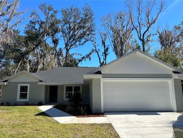 Charming single-story home with gray exterior, green lawn, and a two-car garage at 4721 Nw 67Th St, Ocala, FL 34482