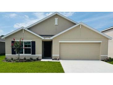 Charming single-story home featuring a two-car garage, well-manicured lawn, and colorful flowering tree at 7136 Se 113Th Ln, Belleview, FL 34420