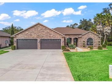 Charming single-story home boasts a stone facade, well-manicured lawn, and a spacious three-car garage at 11084 Se 168Th Loop, Summerfield, FL 34491