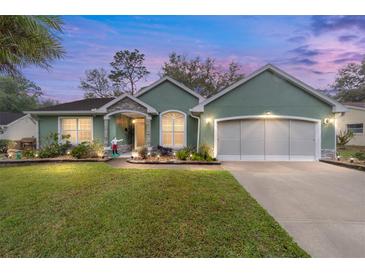 Charming single-story home with a well-manicured lawn, flowering beds, and an attached two-car garage at 11725 79Th Cir, Ocala, FL 34476