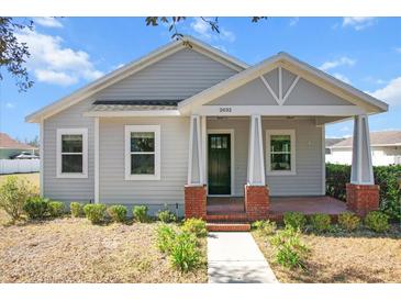 Charming single-story home featuring a welcoming front porch with red brick pillars and a well-manicured lawn at 2032 Se 27Th Rd, Ocala, FL 34471