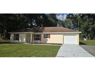 Charming single-story home with a well-manicured lawn and inviting curb appeal at 3373 Se 148Th Pl, Summerfield, FL 34491