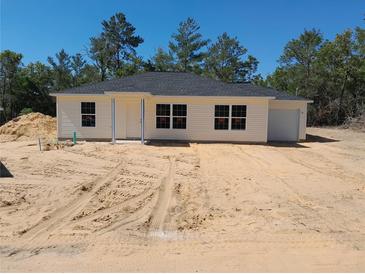 Charming single-story home featuring a cozy front porch and attached one car garage at 46 Malauka Dr, Ocklawaha, FL 32179