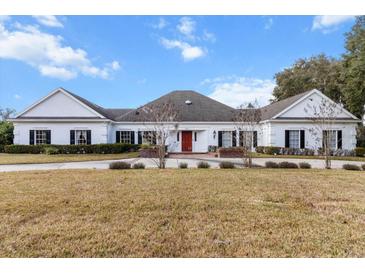 Elegant home with black shutters, brick accents, and a well-manicured lawn offers classic curb appeal at 4620 Nw 84Th Ter, Ocala, FL 34482