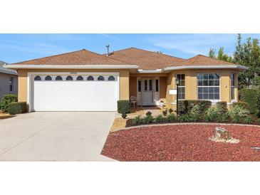 Charming single-story home with a well-maintained lawn, a two-car garage, and colorful rock landscaping at 10003 Sw 90Th Loop, Ocala, FL 34481