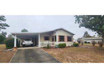 Charming single-story home featuring covered parking, traditional shutters, and low maintenance landscaping at 10060 Sw 93Rd Ave, Ocala, FL 34481