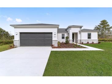 Charming single-story home with a two-car garage, manicured lawn, and modern architectural details at 150 Marion Oaks Golf Rd, Ocala, FL 34473