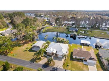 Waterfront home featuring tropical landscaping, private boat dock, and picturesque water views at 1621 Yellow Brick Rd, Astor, FL 32102