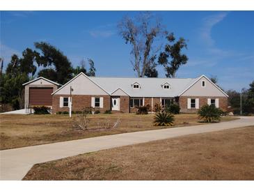 Charming brick home with dormer windows, mature landscaping, and a circular driveway at 3560 Sw 24Th Avenue Rd, Ocala, FL 34471