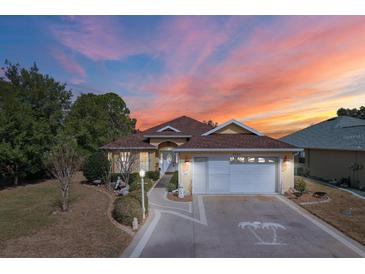 Charming single-story home with a two-car garage, landscaped yard, and a beautiful sunset backdrop at 9285 Sw 90Th St, Ocala, FL 34481