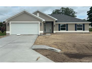 Charming single-story home featuring a two-car garage, well-manicured lawn, and lovely landscaping at 120 Dogwood Drive Cir, Ocala, FL 34472