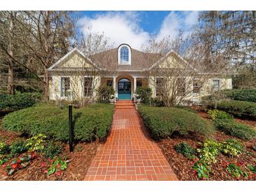 Stunning single Gathering home featuring a brick walkway, lush landscaping and a charming, light yellow facade at 2775 Sw 53Rd St, Ocala, FL 34471
