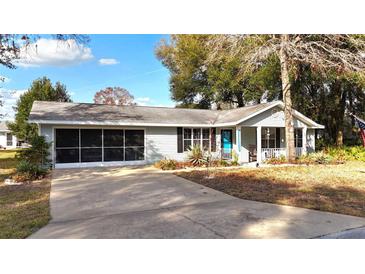 Charming single story home featuring screened in garage, well maintained landscaping and a pop of color with a blue front door at 10823 Sw 83Rd Ave, Ocala, FL 34481