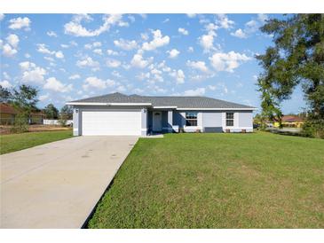 Charming single-story home with a well-manicured lawn and attached two car garage at 14560 Sw 25Th Ter, Ocala, FL 34473