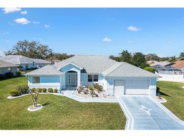 Charming single-story home with a well-manicured lawn and patterned driveway on a sunny day at 17755 Se 117Th Cir, Summerfield, FL 34491