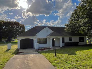 Charming single-story home with a well-manicured lawn, attached garage, and inviting curb appeal at 301 Oak Track Way, Ocala, FL 34472