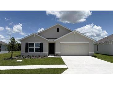 Charming single-story home with a two-car garage and a well-manicured lawn at 8502 Las Palmas Way, Wildwood, FL 34785