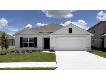 Charming single-story home featuring a two-car garage, well-manicured lawn and a neutral color palette at 8506 Las Palmas Way, Wildwood, FL 34785