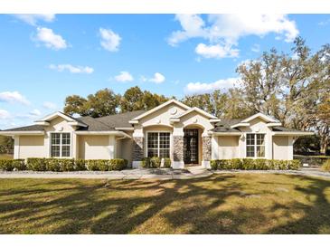 Beautiful single-story home with stone accents, manicured lawn and a welcoming entrance at 10215 Sw 134Th Ct, Dunnellon, FL 34432