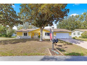 Charming yellow home with a spacious front yard and a well-maintained lawn at 11620 Sw 84Th Avenue Rd, Ocala, FL 34481