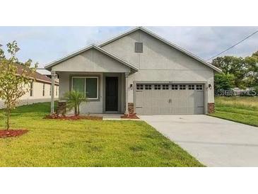 A charming single-Gathering home featuring a well-manicured lawn and a two-car garage at 2259 Nw 2Nd Ave, Ocala, FL 34475