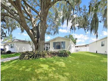 Charming single-story home featuring a well-maintained lawn and beautiful mature trees offering plenty of shade at 615 Ne Cottage Park Ln, Leesburg, FL 34748