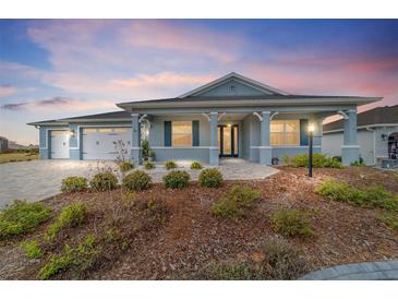 Charming one-story home with blue exterior, landscaped front yard, and attached two-car garage at 8107 Sw 92Nd Cir, Ocala, FL 34481