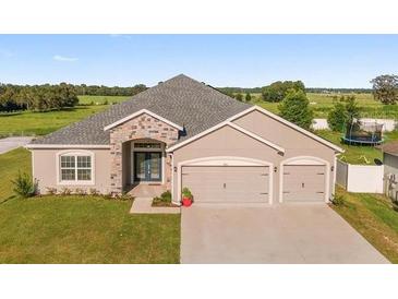 Charming single-story home featuring a two-car garage and manicured front lawn at 9105 Se 55Th Ter, Ocala, FL 34480