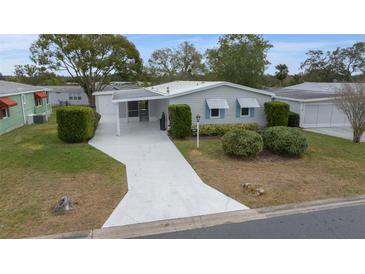 Charming home with a spacious driveway and well-manicured landscaping that enhances its curb appeal at 1541 Hillcrest Dr, Lady Lake, FL 32159