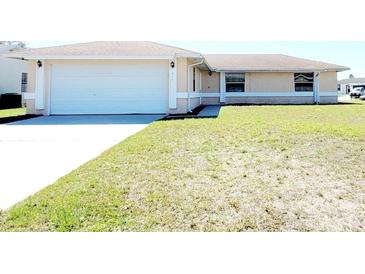 Charming single-story home featuring a two-car garage and a spacious front lawn at 434 Bar Ct, Kissimmee, FL 34759