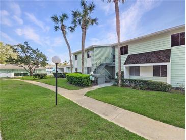 Two-story condo featuring palms, green spaces, and convenient stair access at 527 Midway Dr # A, Ocala, FL 34472