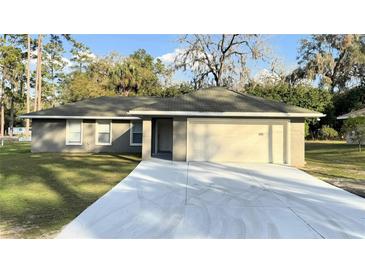 Charming single-story home featuring an attached two-car garage and a well-manicured front lawn at 5305 Se 26Th Ave, Ocala, FL 34480