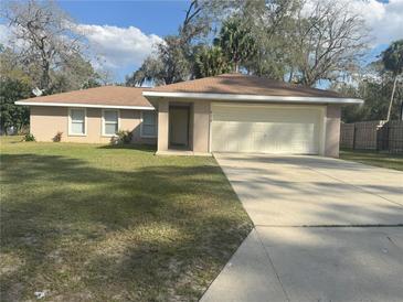 Charming single-story home with a well-manicured lawn and an attached two-car garage at 5315 Se 26Th Ave, Ocala, FL 34480