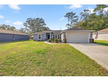 Charming single-story home with a well-manicured lawn and attached two-car garage at 5488 Nw 61St Ave, Ocala, FL 34482