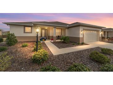 Charming single-story home featuring a well-manicured front yard, inviting entrance, and attached two-car garage at 8874 Sw 104Th Cir, Ocala, FL 34481