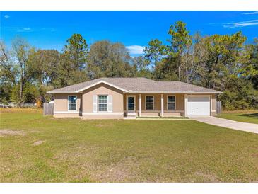 Charming single-story home featuring a well-manicured front lawn, neutral paint, and an attached one-car garage at 13 Pine Course Radl, Ocala, FL 34472