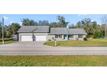 Charming single-story home featuring an attached two-car garage and well-maintained front lawn at 7010 Nw 44Th Ave, Ocala, FL 34482