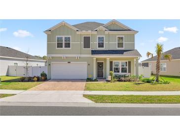 Charming two-story home with a manicured front lawn, brick-paved driveway, and welcoming front porch at 1681 Nw 44Th Ct Rd, Ocala, FL 34482