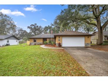 Charming single-story home with a manicured front lawn and an attached two-car garage at 5205 Ne 3Rd St, Ocala, FL 34470