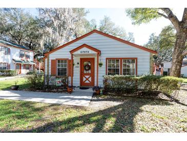 Charming single-story home featuring a decorative front door, tidy landscaping and a well-maintained lawn at 7972 Midway Drive Ter # O103, Ocala, FL 34472