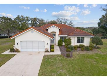 Charming home with a red tile roof, well-manicured landscaping, and an inviting front entrance at 8223 Sw 113Th Ln, Ocala, FL 34481