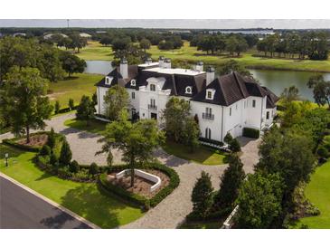 Stunning luxury home with a circular driveway and manicured landscaping near a golf course and lake at 8482 Nw 31St Lane Rd, Ocala, FL 34482